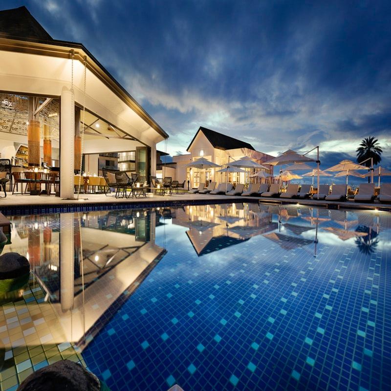 Hotel tropical con piscina y palmeras